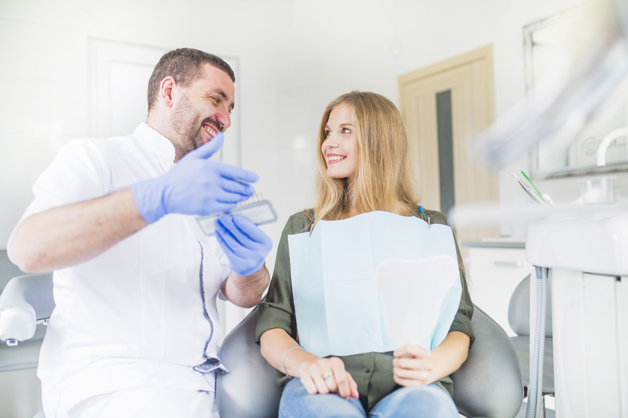 happy-dentist-patient-looking-each-other-while-choosing-color-tone-her-teeth